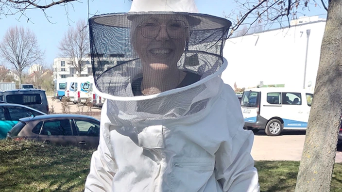 Eine Frau in einem Imkeranzug