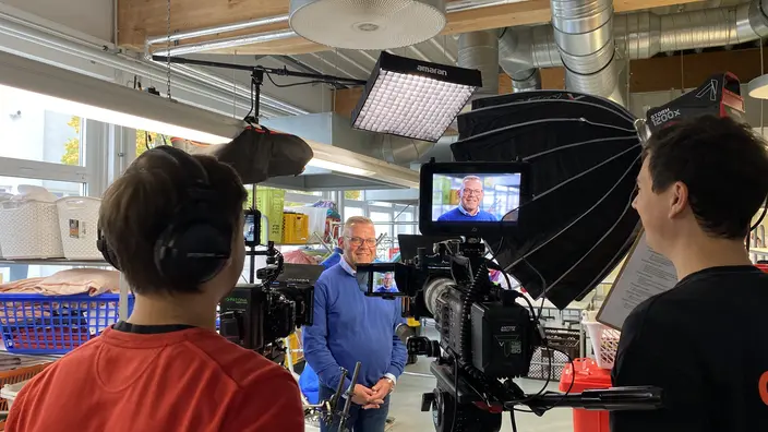  Ein Kamerateam führt in der Wäscherei ein Interview mit einem CJD-Mitarbeiter.